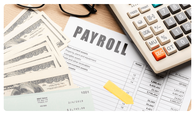 Payroll document beside cash, a checkbook, and a calculator