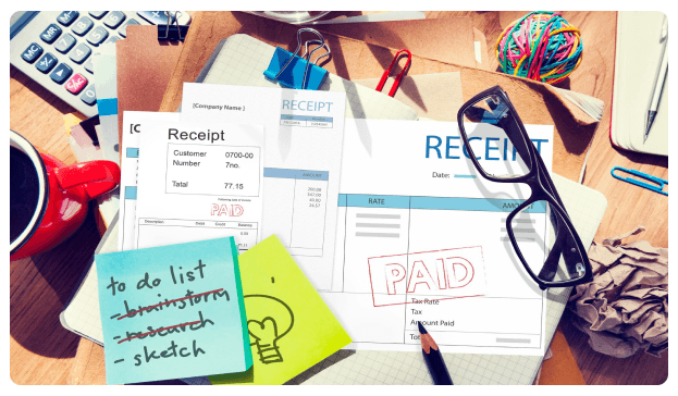 Receipts, a to-do list, and paid stamps spread across a desk