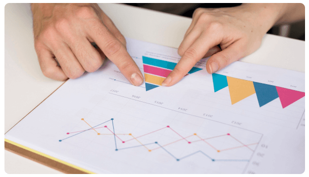 Hands pointing at a colorful variance analysis chart on paper