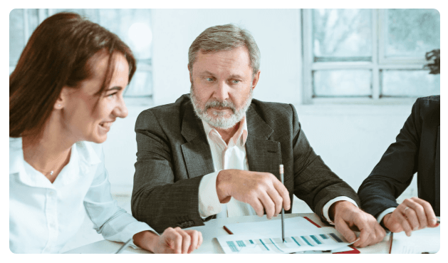Two colleagues reviewing financial charts across a meeting table