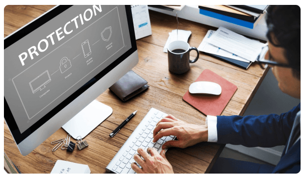 Computer monitor displaying the word 'Protection' with security icons on a desk