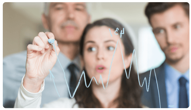 Financial expert drawing a fluctuating trend line on a glass board