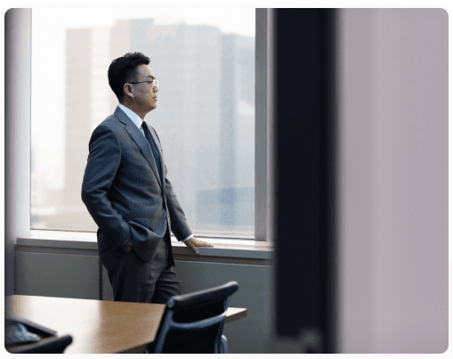 Man in a suit looking out of an office window