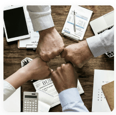 Team fist bump over a desk