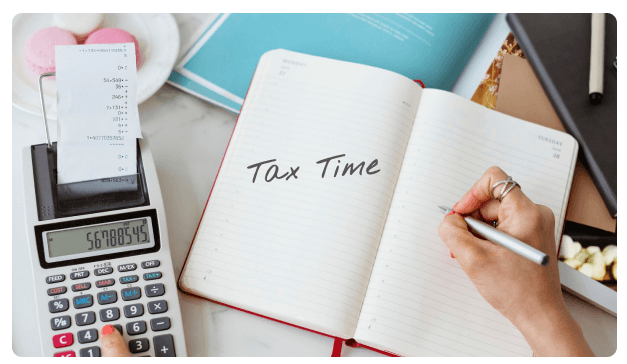 Calculator receipt beside a notebook reading Tax Time