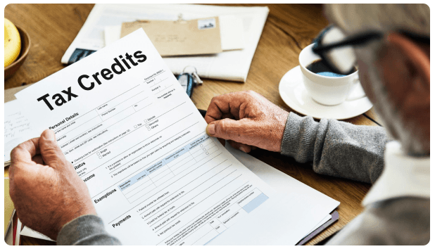 Person reviewing a printed Tax Credits document over coffee