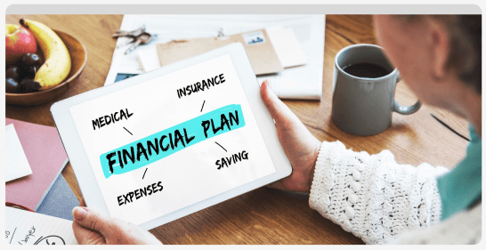 Tablet displaying a financial plan next to coffee and fresh fruit